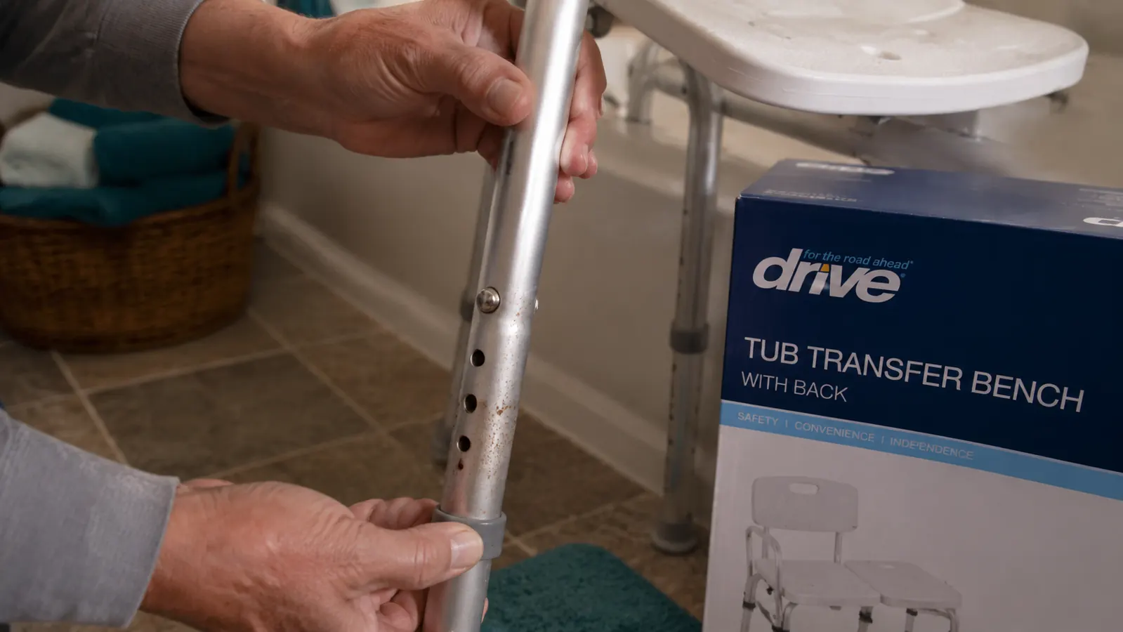 Transfer bench aluminum legs showing early surface rust spots at the adjustment holes after months of wet bathroom use